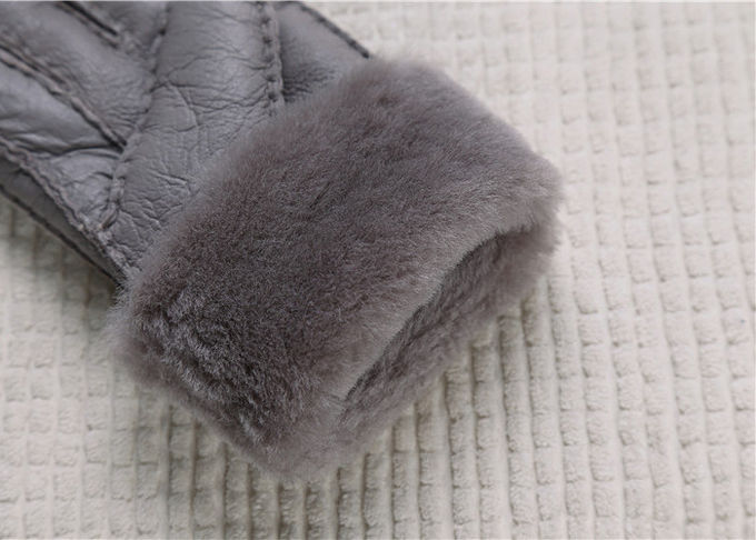 Les gants gris de peau de mouton les plus chauds rayés vraie par fourrure lissent la surface avec le doigt