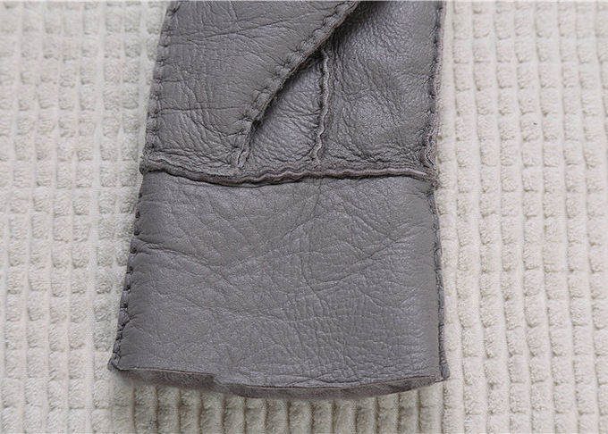 Les gants gris de peau de mouton les plus chauds rayés vraie par fourrure lissent la surface avec le doigt